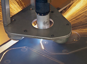 Plasma torch cutting nested parts in close up photo